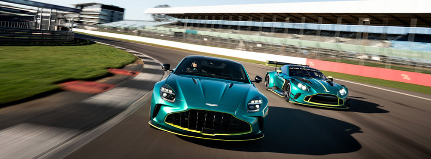 Two green race cars driving side by side on a racetrack